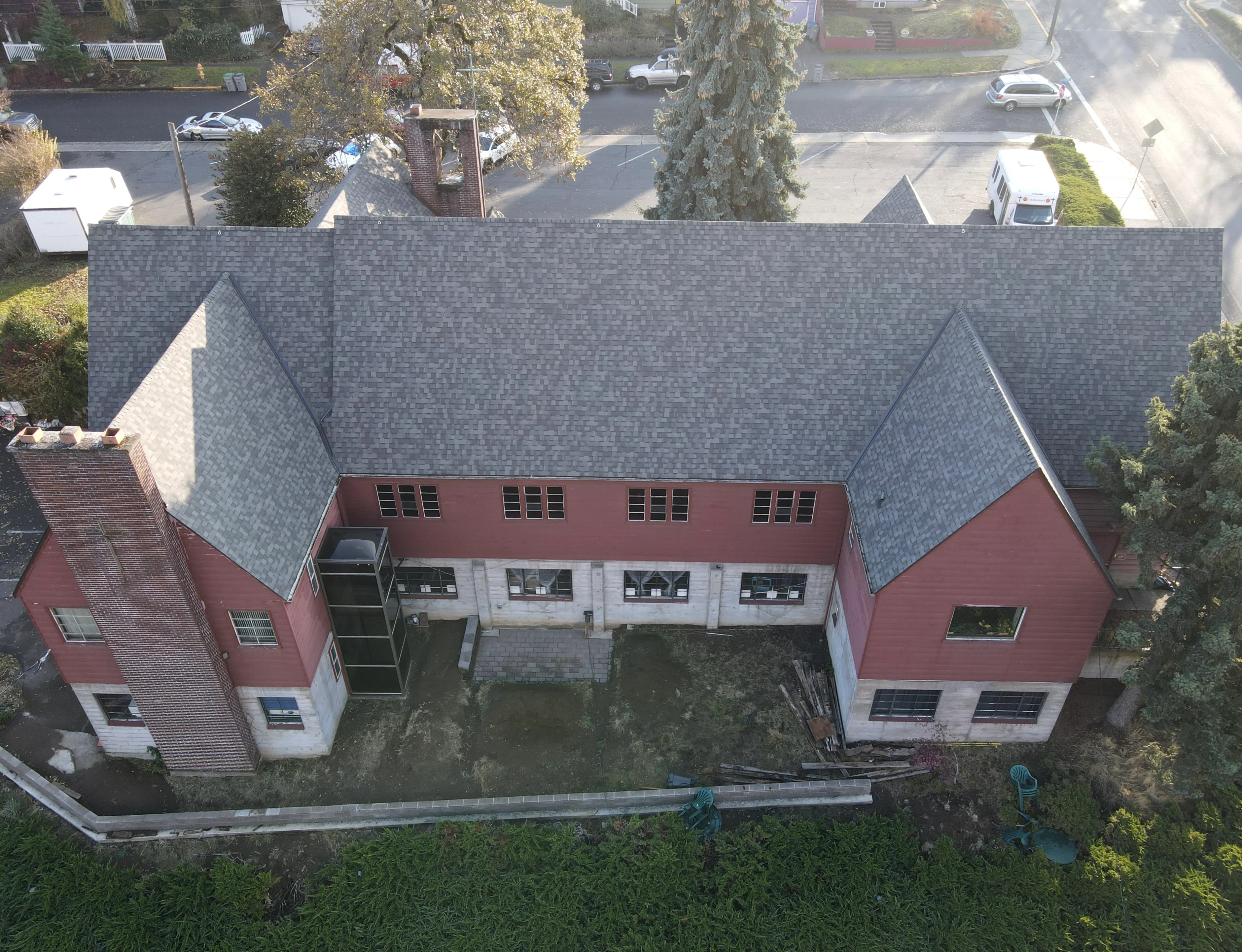 Aerial view of residential roof with gray dimensional shingles and multiple gabled sections