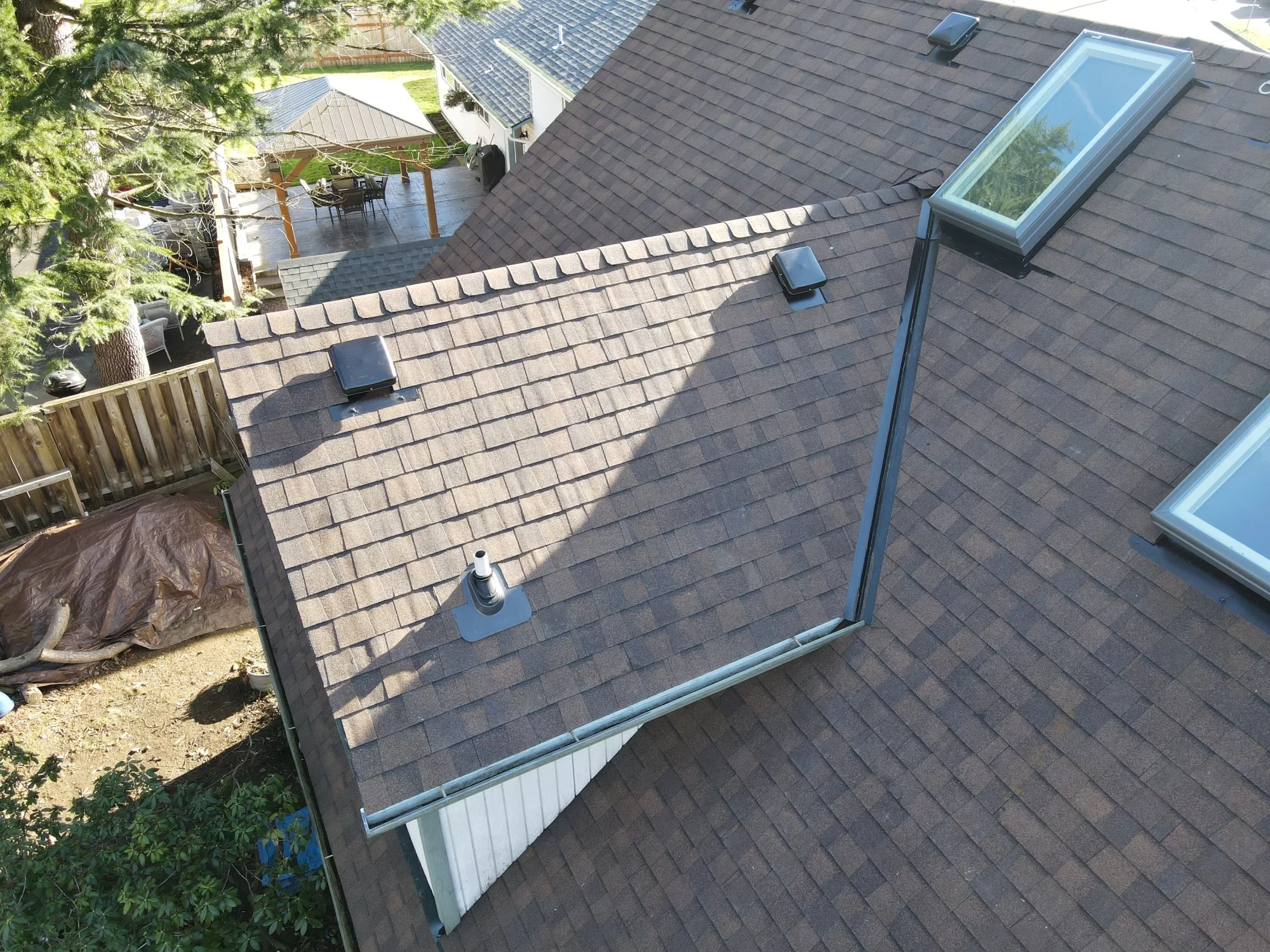 Aerial view of new architectural shingle roof with skylights and metal gutters